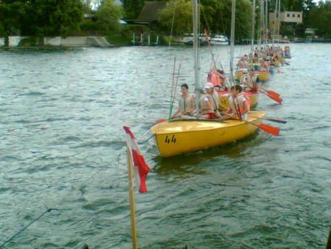 Die Kids mit den Paddeln in den Segelbooten